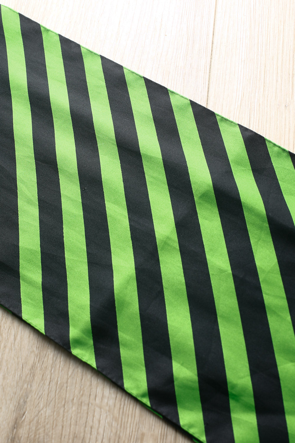 Green and black striped satin scarf with diagonal stripes, lightweight vintage accessory for versatile styling.