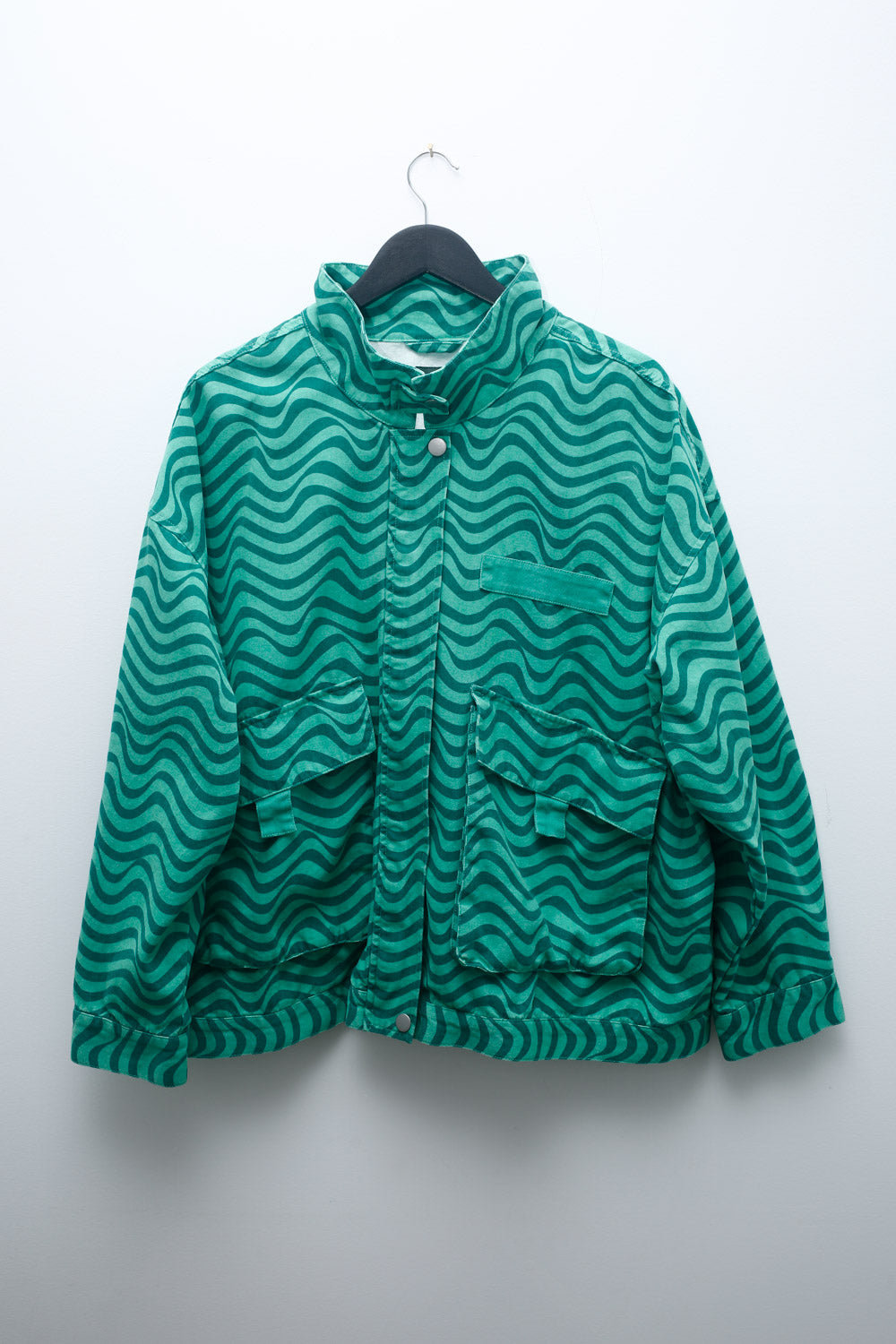 90s green bomber jacket with wavy print, snap buttons, and utility pockets