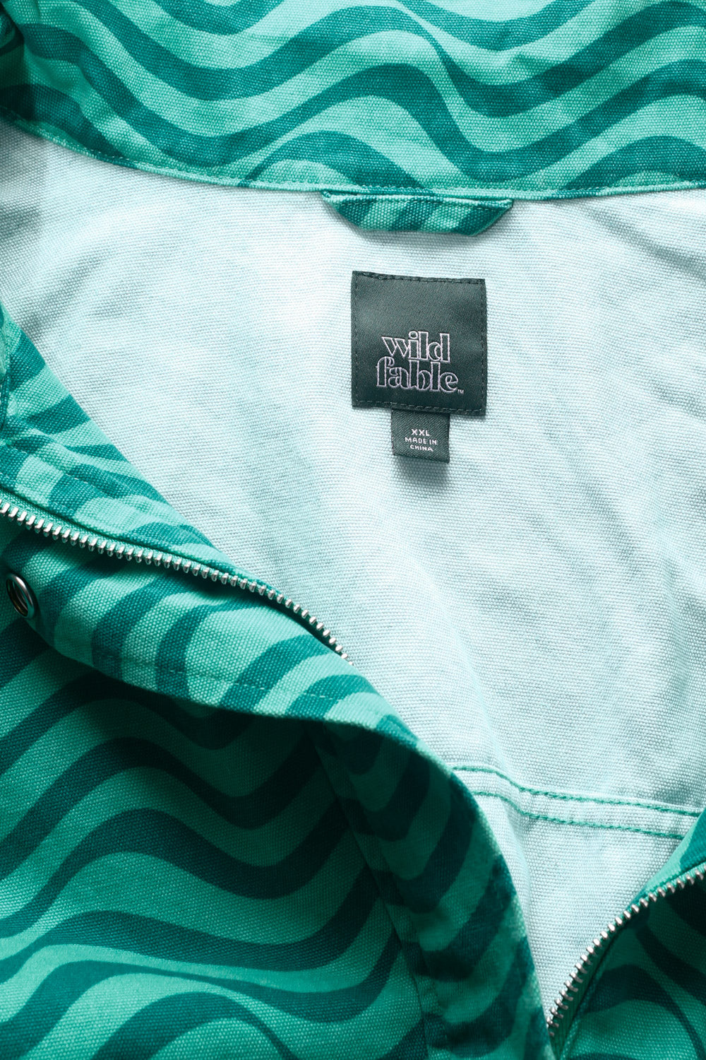 90s green bomber jacket with wavy print, snap buttons, and utility pockets