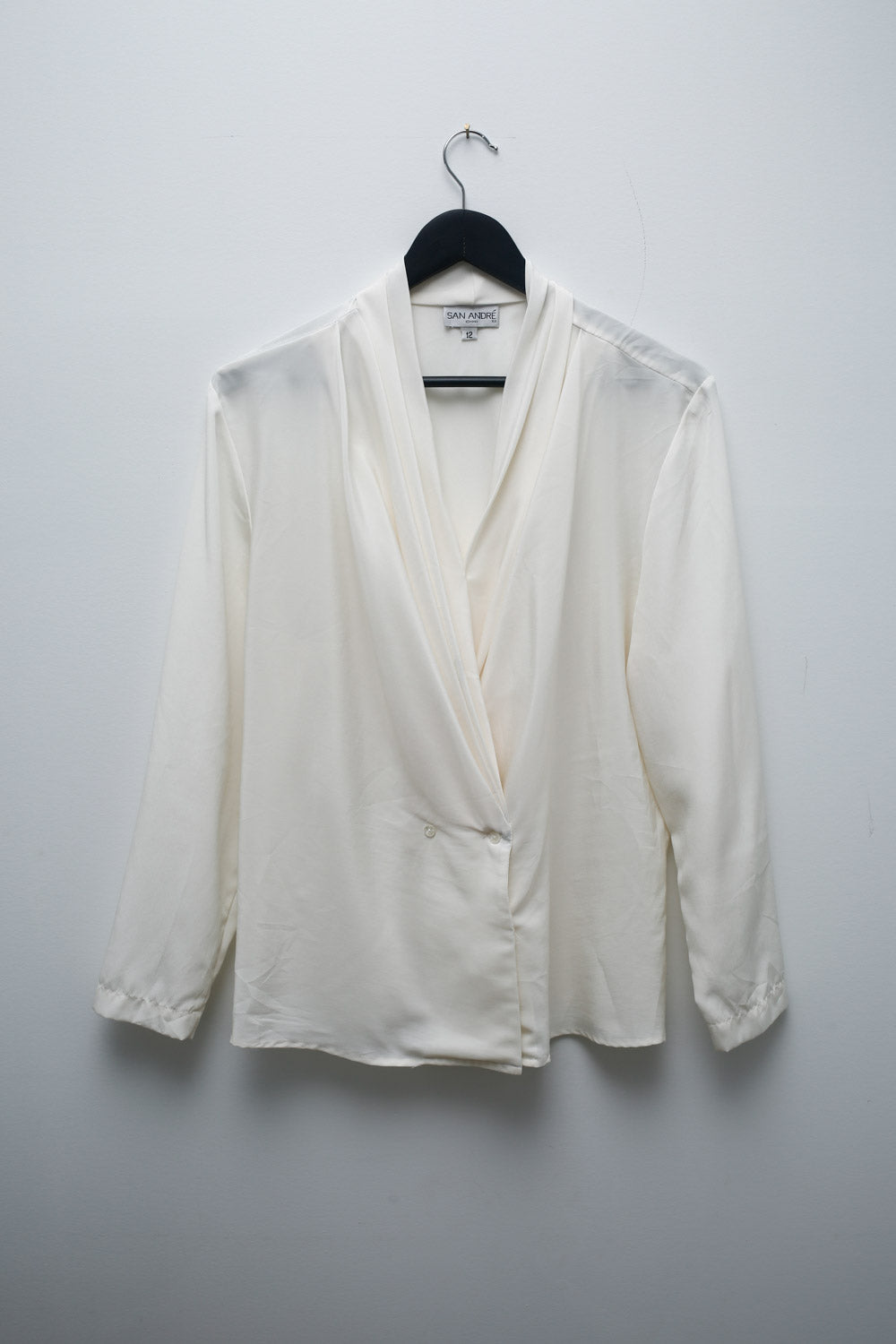 Vintage San André white satin blouse with draped wrap-style front, long sleeves, pleated neckline, and button closure.