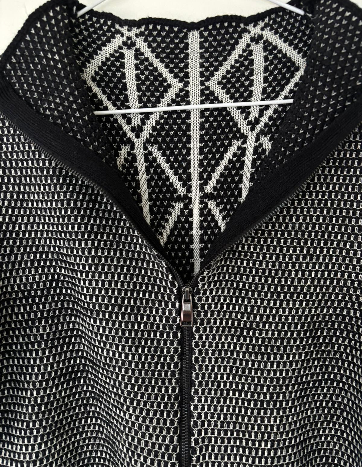 Close-up of a textured black and white garment with a zipper